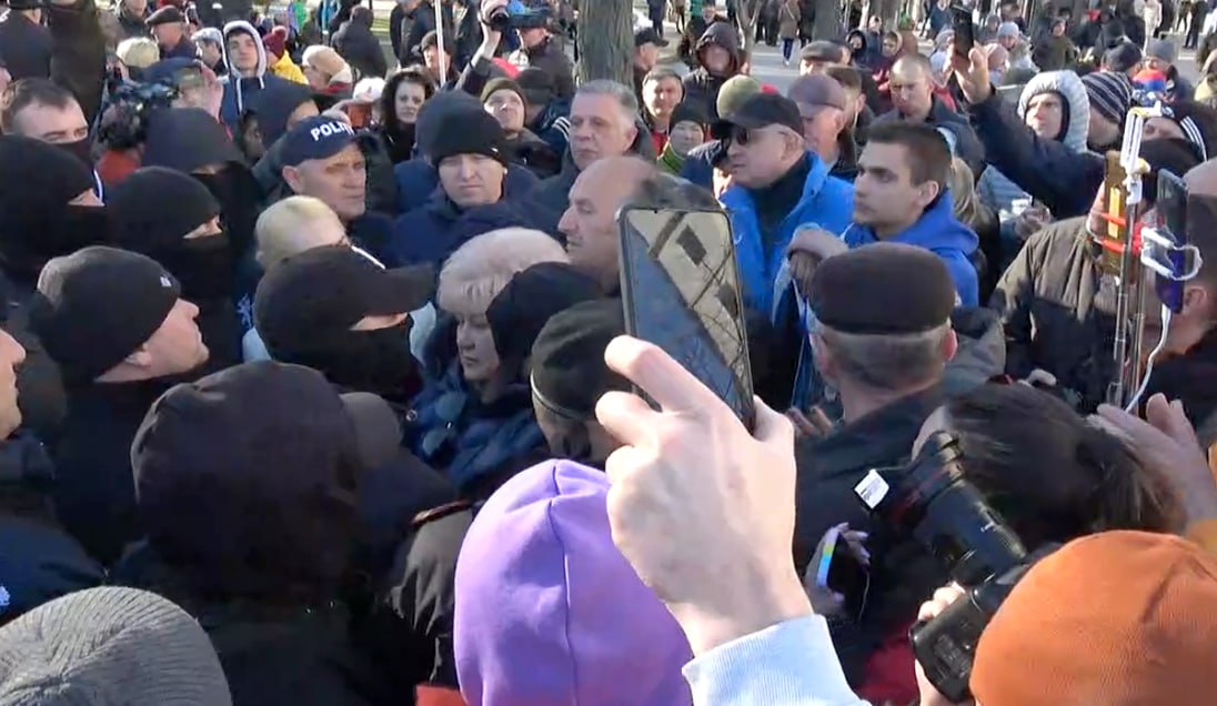 De mai bine de 15 minute fruntașii Partidului Șor, printre care Tauber și Apostolova, stau față în față cu Poliția, fără ca să se întâmple nimic. Asta deși protestul s-a încheiat cu aproape jumătate de oră în urmă. Protestatarii aruncă critici în direcția polițiștilor