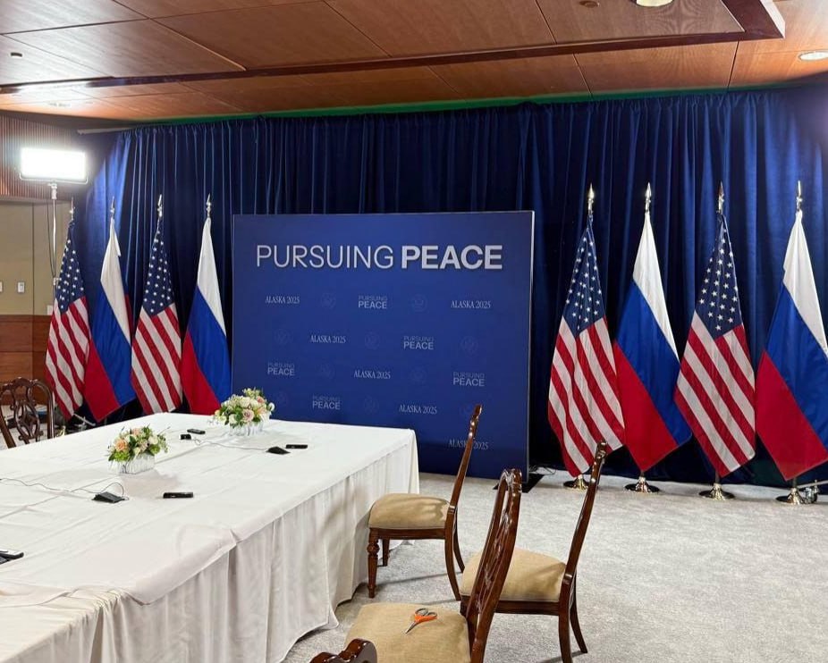 Masa negocierilor, pregătită pentru Trump și Putin în Alaska, cu sloganul: __În căutarea păcii.__